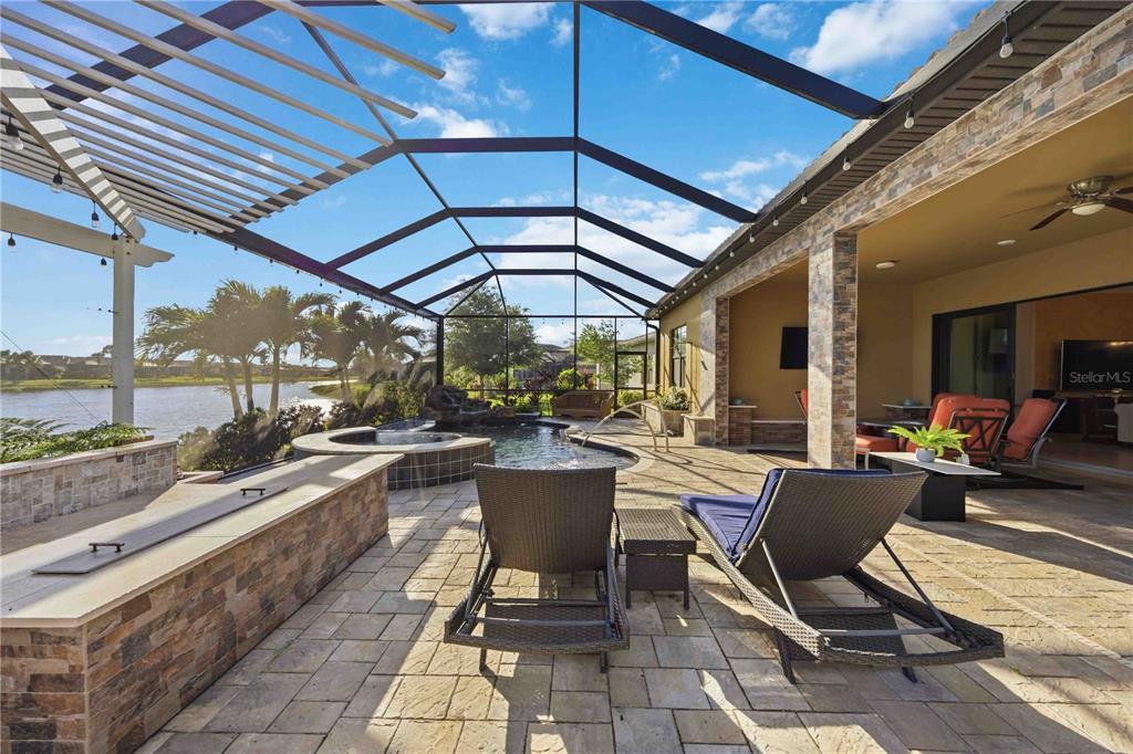 13349 Verandi Street Venice, FL 34293 - Photo 36 of 76 a view of a patio with a dining table and chairs under an umbrella