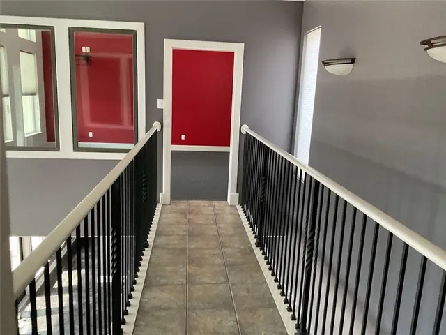 a view of a hallway with wooden floor and stairs