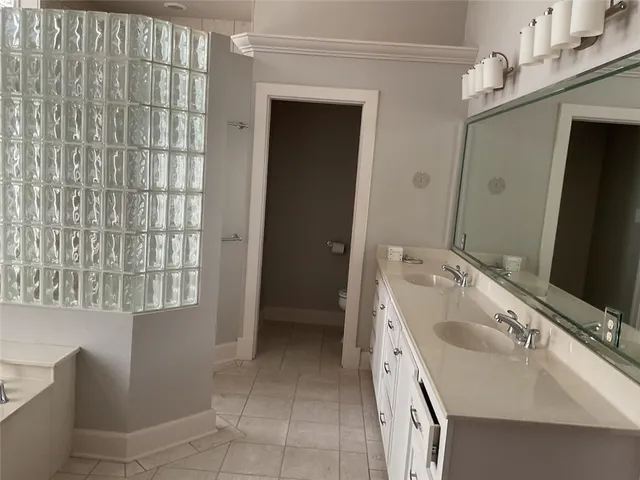 a spacious bathroom with a double vanity sink a mirror and a bathtub
