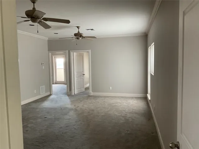 en empty room with windows and ceiling fan