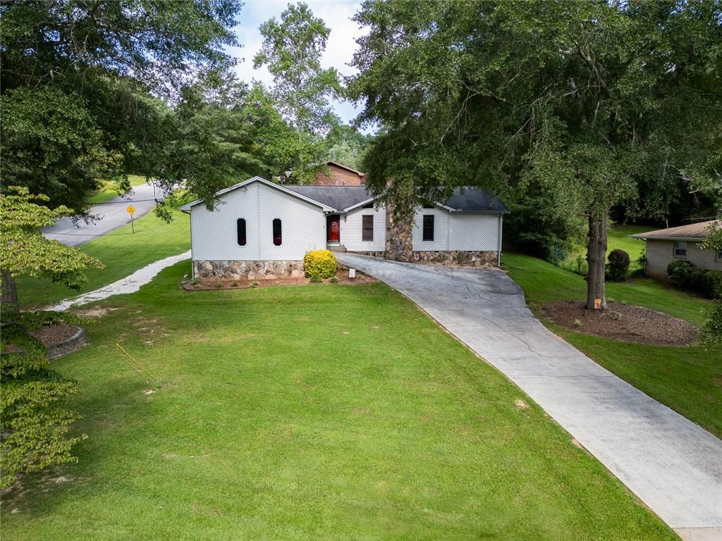 2966 Riviera Drive Conyers, GA 30012 - Photo 44 of 63 a house that is sitting in the grass with large trees
