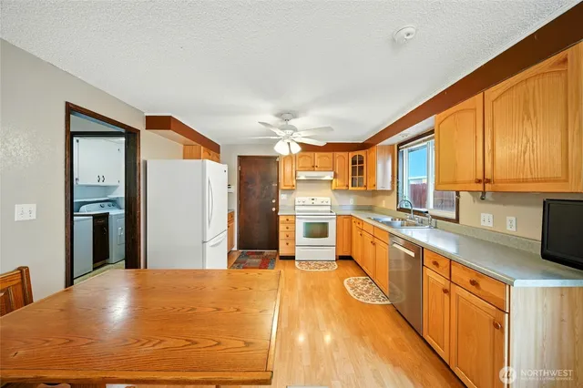 a large kitchen with a window and stainless steel appliances