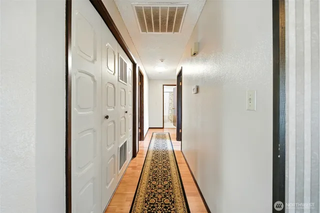 a view of a hallway with wooden floor and staircase
