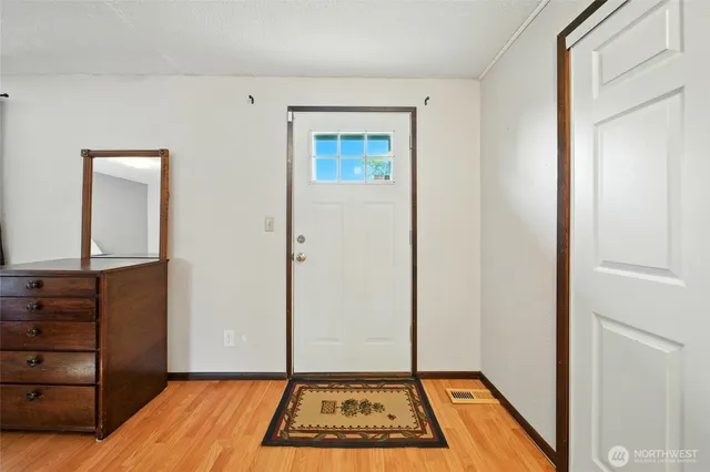 a view of a bedroom with wooden floor and cabinet