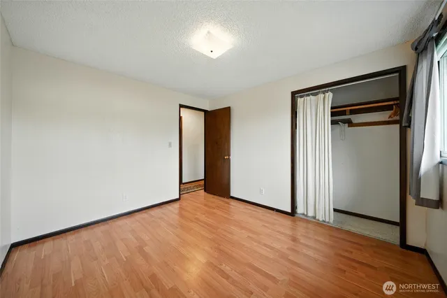 a view of empty room with wooden floor