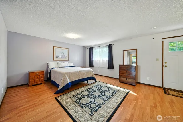 a bedroom with a bed rug and wooden floor