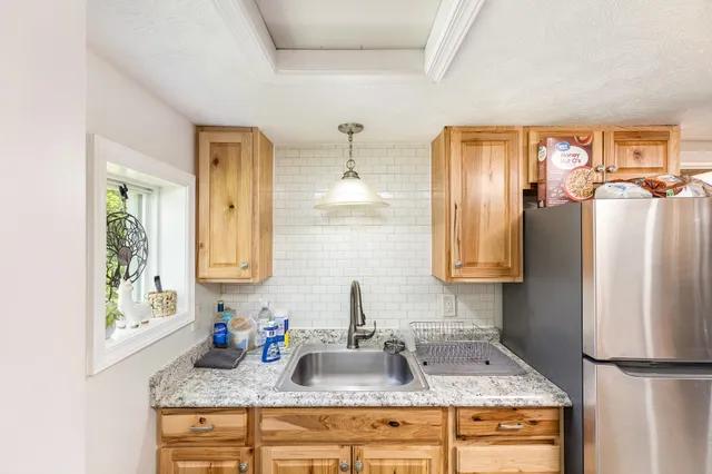 a bathroom with granite countertop a sink and a refrigerator