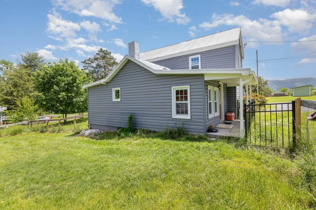 a view of a house with a yard and fence