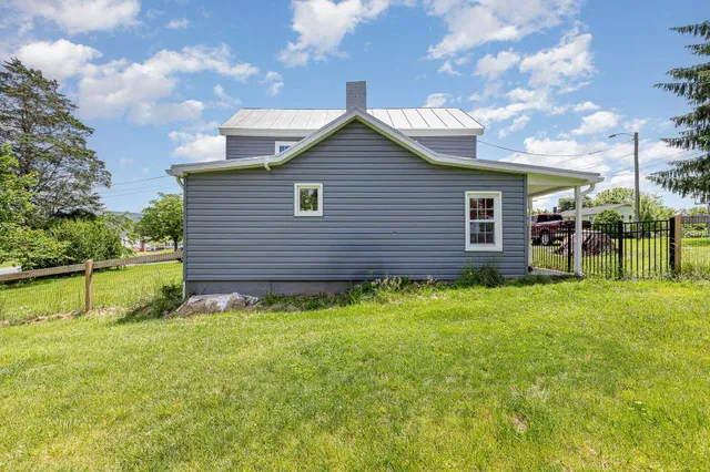 a backyard of a house with table and chairs