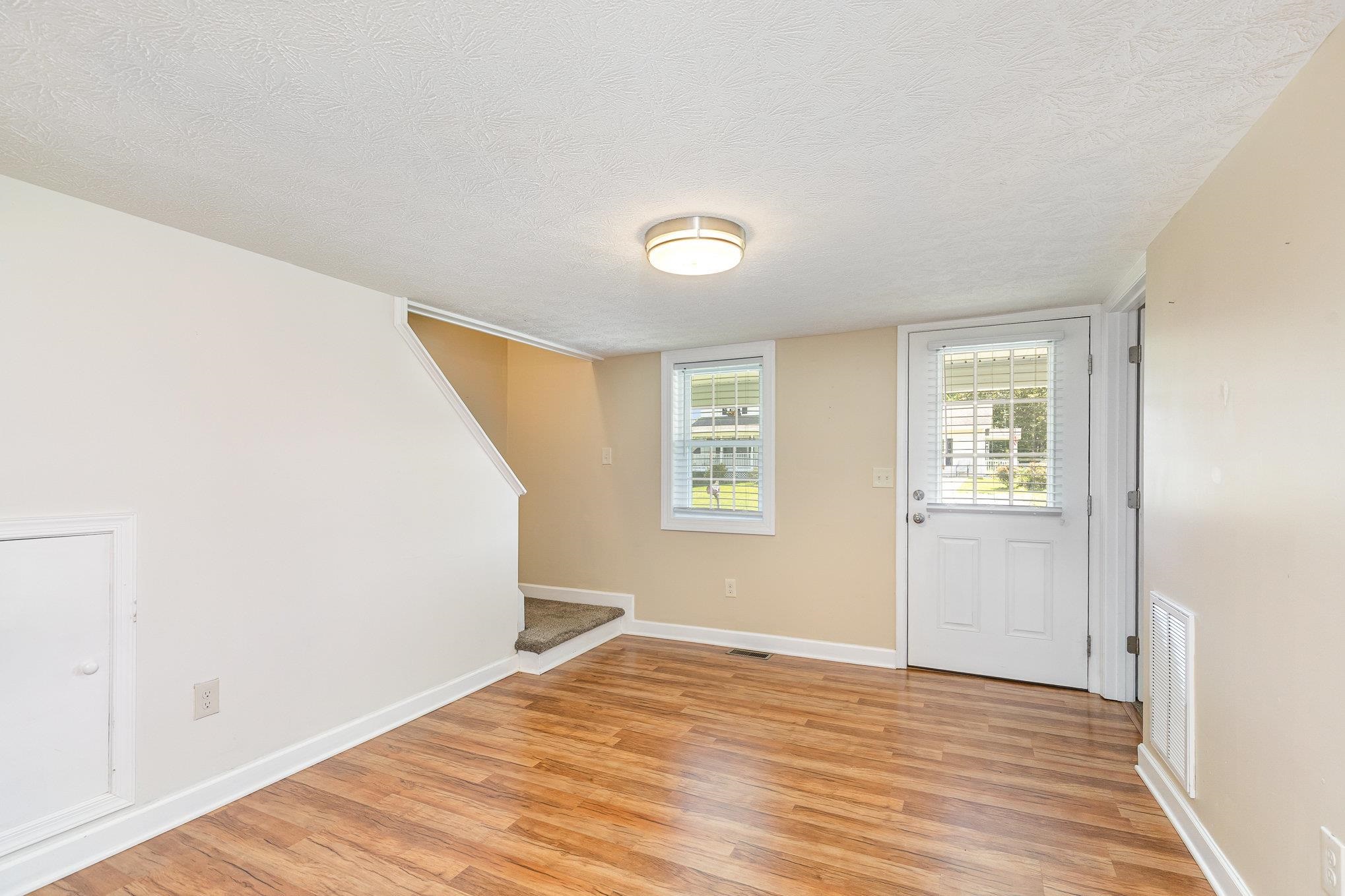 406 6th Street Luray, VA 22835 - Photo 7 of 28 a view of an empty room with wooden floor and a window