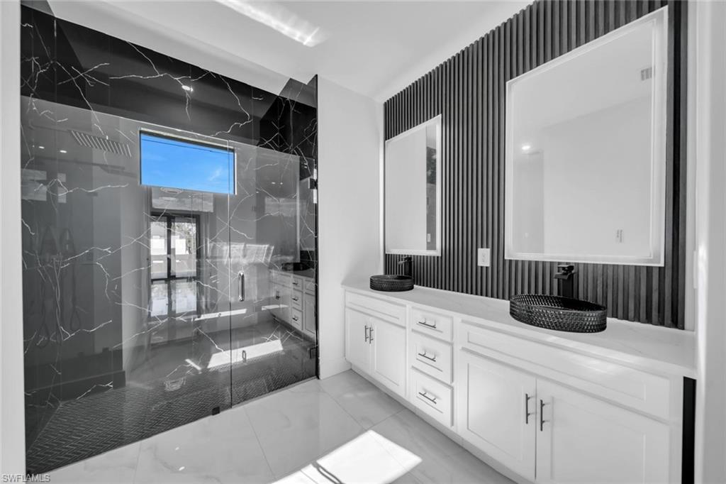 3312 17th Street Southwest Lehigh Acres, FL 33976 - Photo 9 of 12 a bathroom with a sink a mirror and a shower