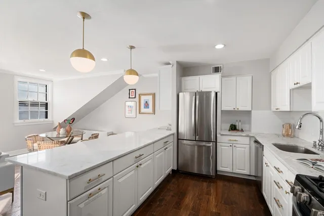 a kitchen with white cabinets and stainless steel appliances