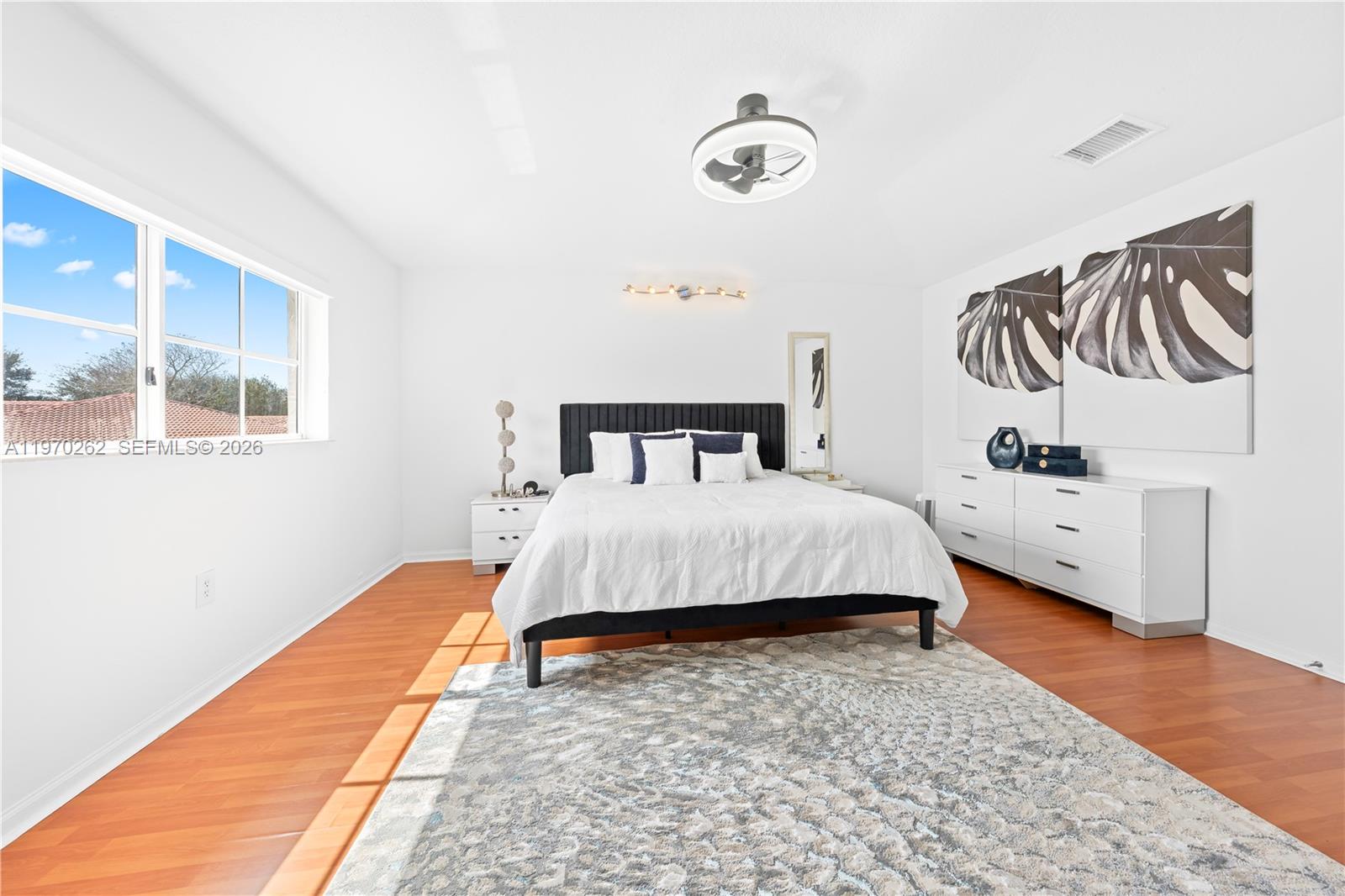 12858 Southwest 50th Street Miramar, FL 33027 - Photo 13 of 36 a bedroom with a bed and wooden floor