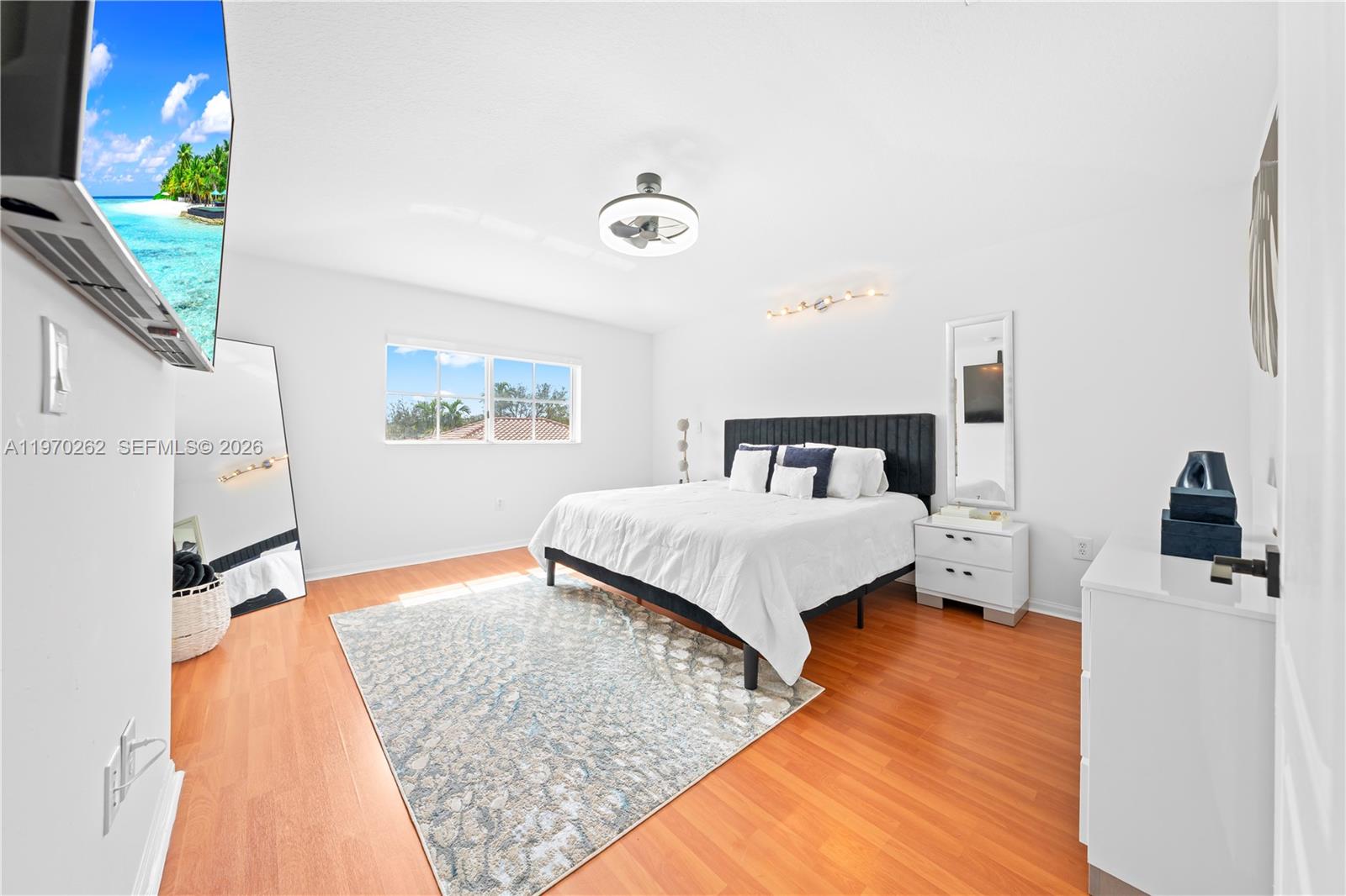 12858 Southwest 50th Street Miramar, FL 33027 - Photo 14 of 36 a bedroom with a bed and a flat tv screen on a dresser