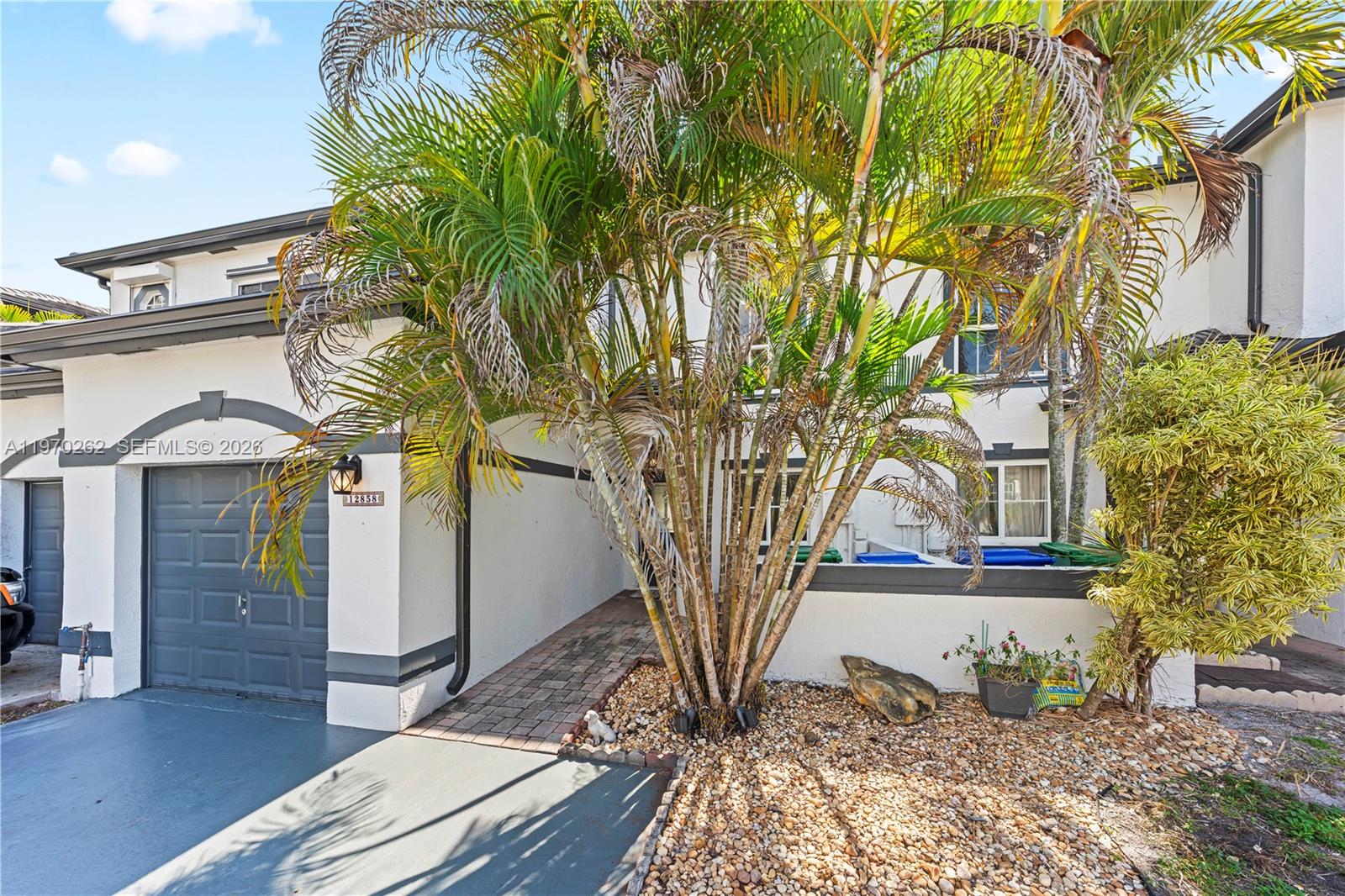 12858 Southwest 50th Street Miramar, FL 33027 - Photo 2 of 36 a front view of a house with garden
