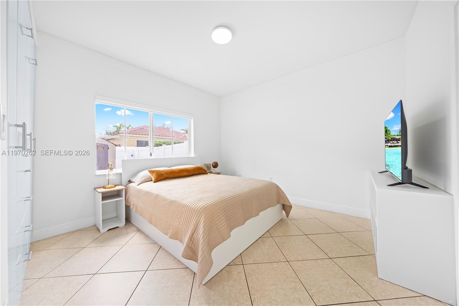 12858 Southwest 50th Street Miramar, FL 33027 - Photo 24 of 36 a bedroom with a bed and a flat screen tv