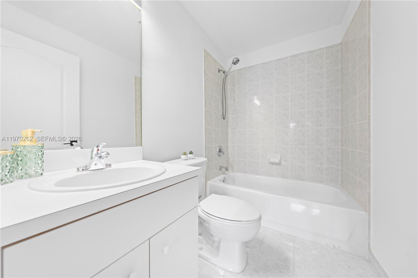 12858 Southwest 50th Street Miramar, FL 33027 - Photo 27 of 36 a bathroom with a bathtub shower sink vanity mirror and toilet