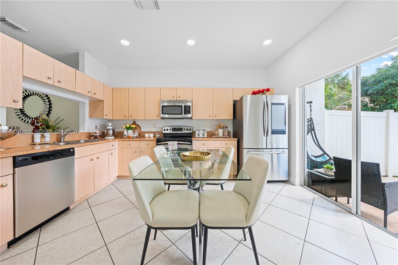12858 Southwest 50th Street Miramar, FL 33027 - Photo 8 of 36 a kitchen with stainless steel appliances a stove a refrigerator a sink and white cabinets with wooden floor