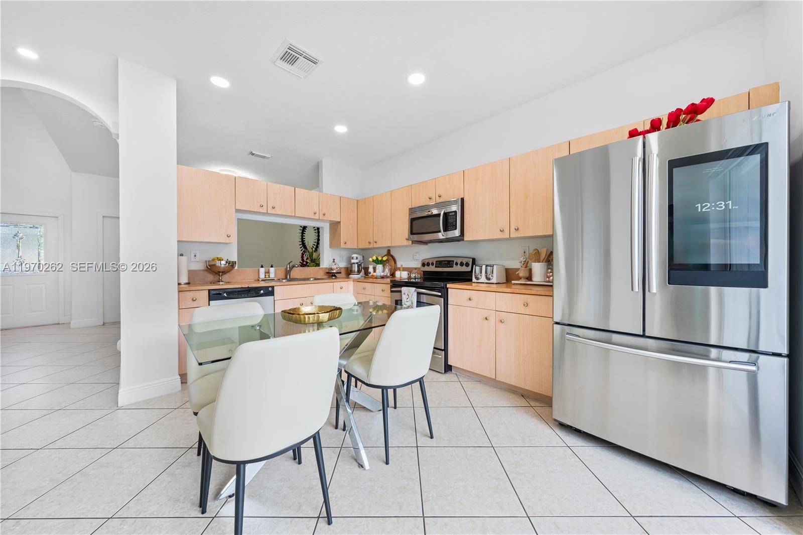 12858 Southwest 50th Street Miramar, FL 33027 - Photo 9 of 36 a kitchen with white cabinets and refrigerator