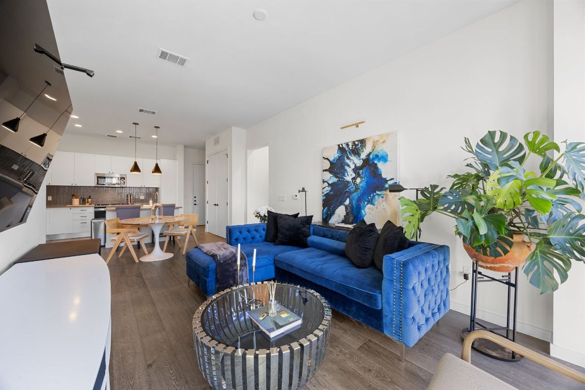 800 Embassy Drive, Unit 229 Austin, TX 78702 - Photo 16 of 40 a living room with furniture a chandelier and a potted plant