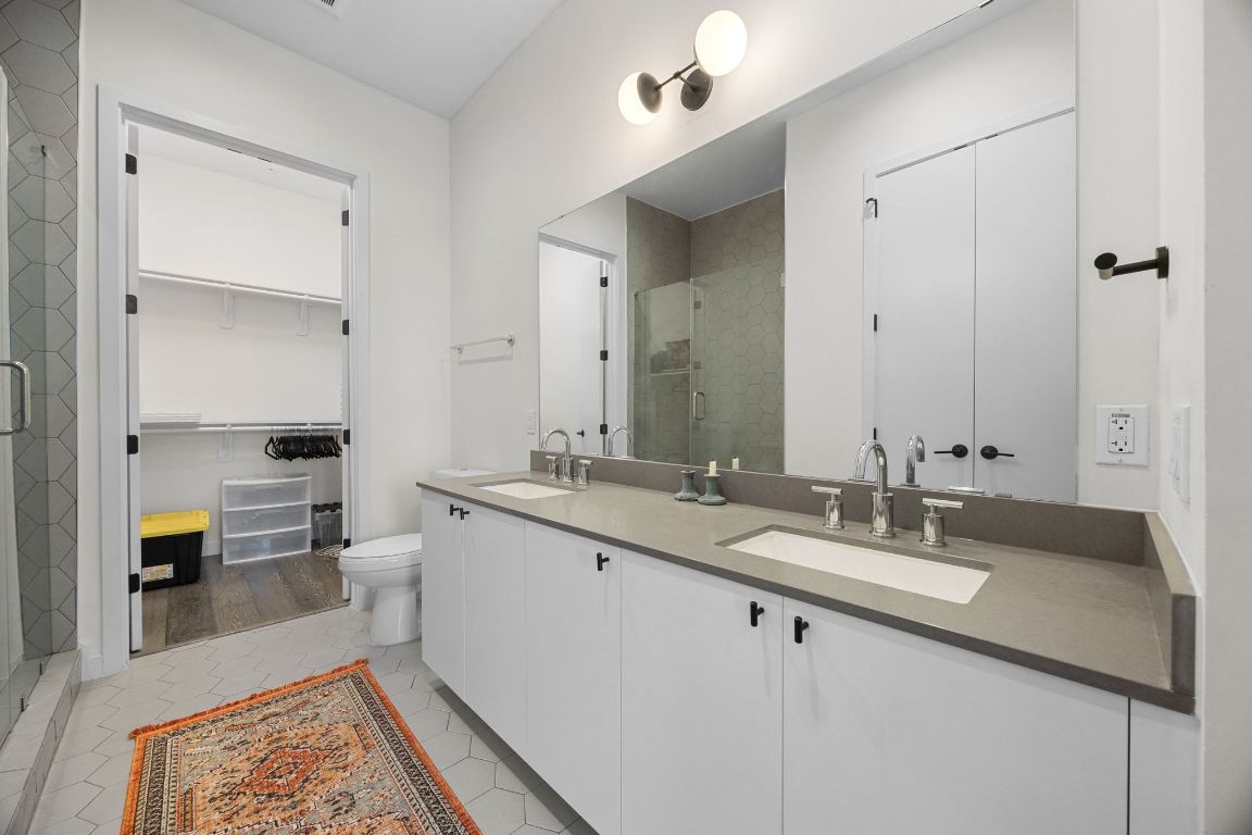 800 Embassy Drive, Unit 229 Austin, TX 78702 - Photo 22 of 40 a spacious bathroom with a double vanity sink toilet and a tub