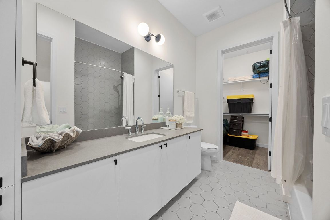 800 Embassy Drive, Unit 229 Austin, TX 78702 - Photo 27 of 40 a en suite bathroom with a double vanity and a mirror