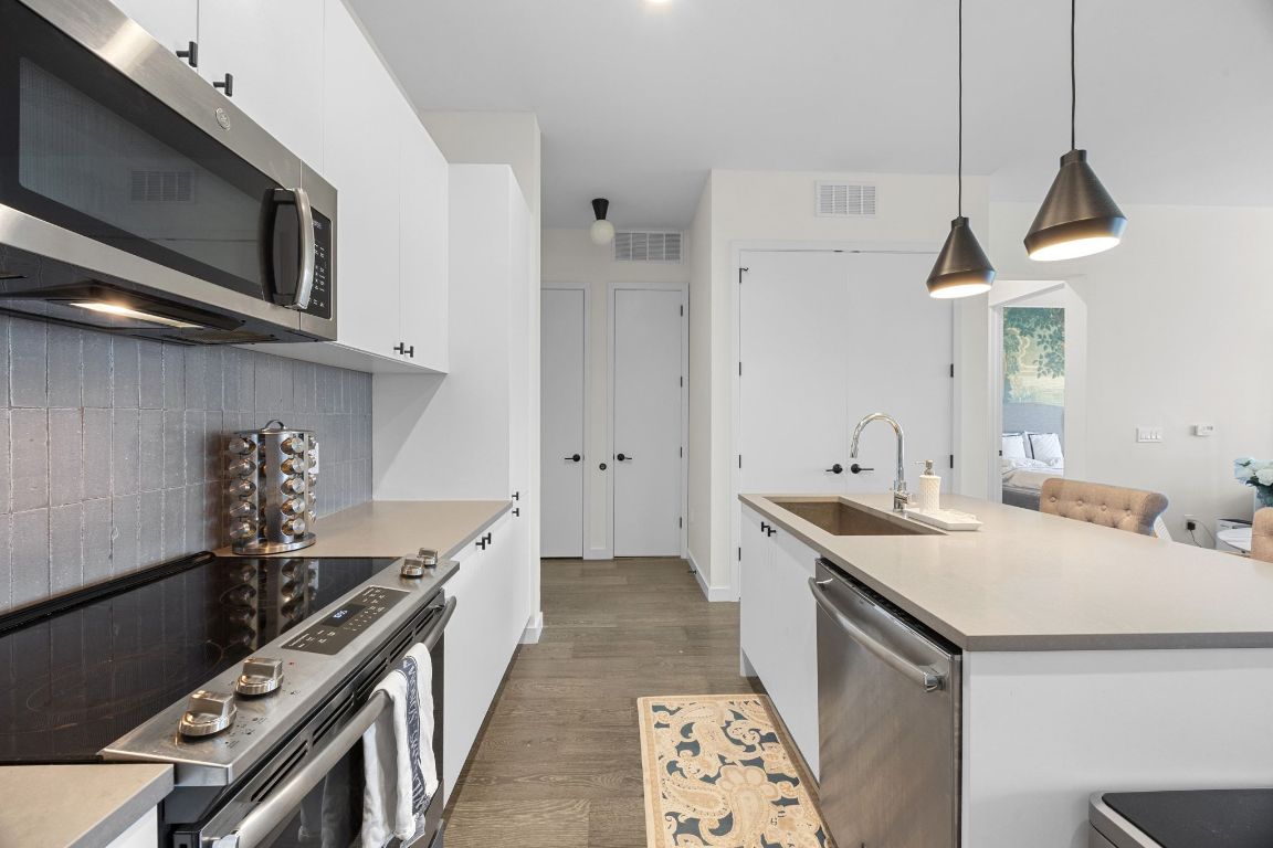 800 Embassy Drive, Unit 229 Austin, TX 78702 - Photo 5 of 40 a kitchen with stainless steel appliances a sink stove and cabinets