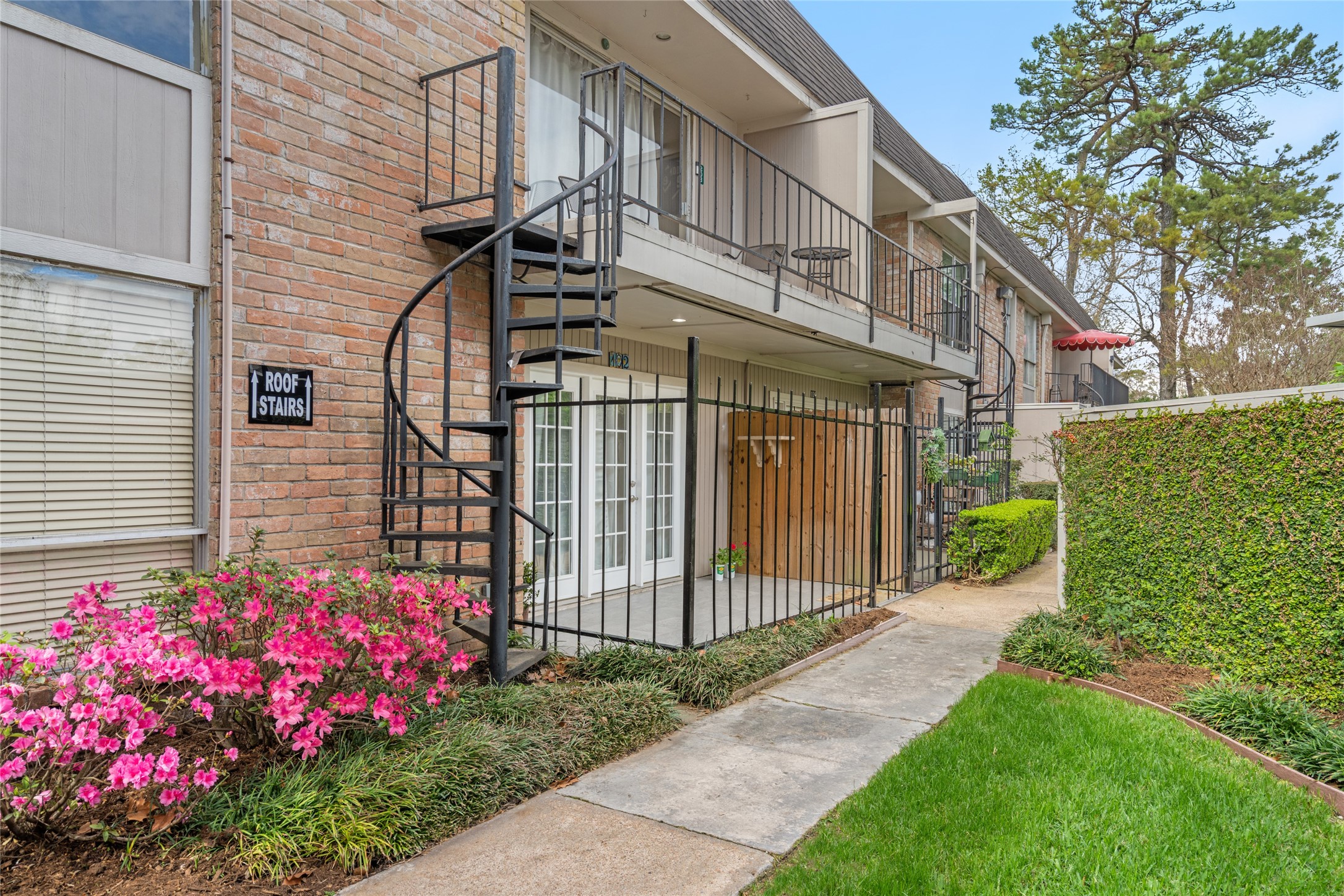 2238 South Piney Point Road, Unit 102 Houston, TX 77063 - Photo 1 of 20 a view of a house with a small yard and flower plants