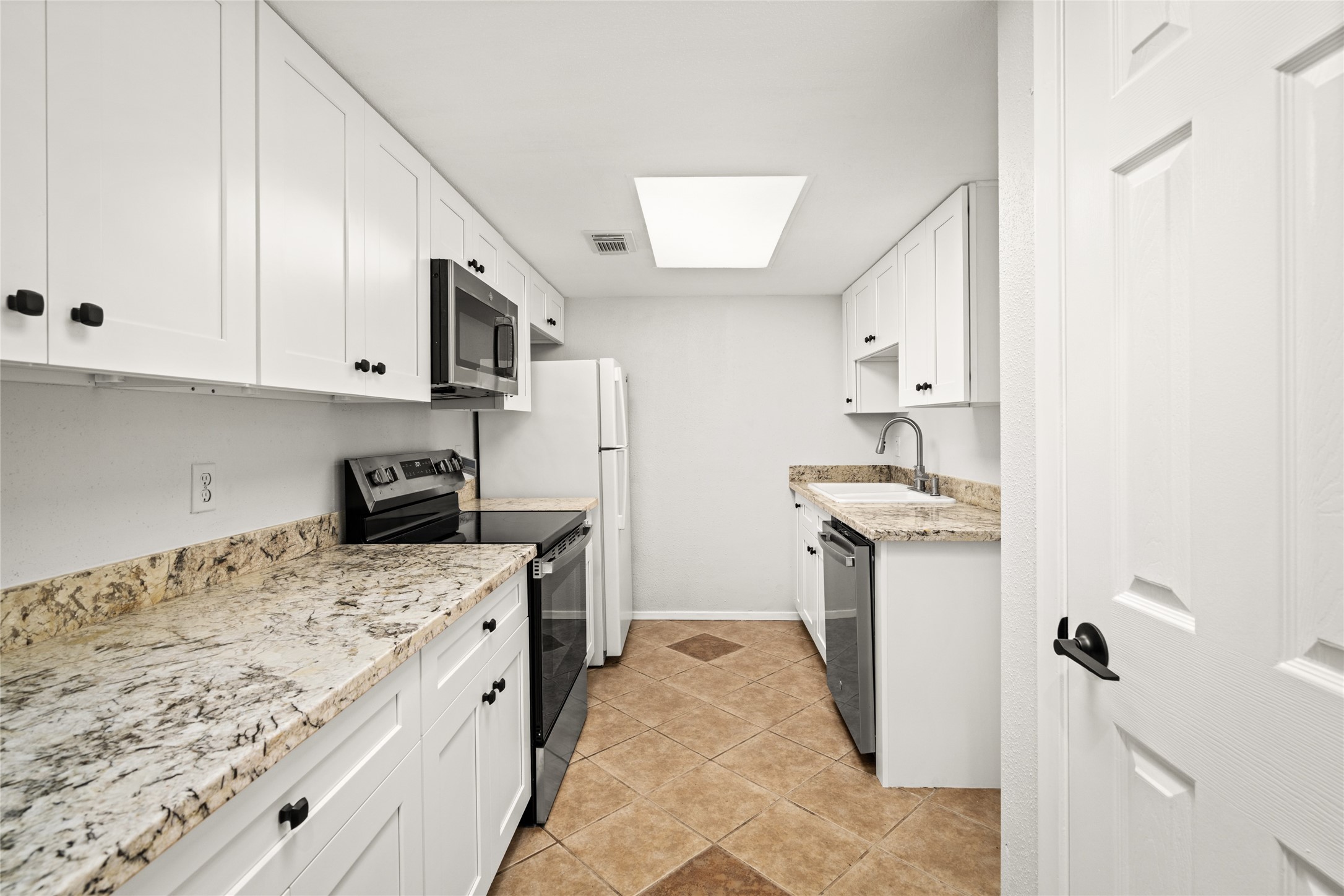 2238 South Piney Point Road, Unit 102 Houston, TX 77063 - Photo 6 of 20 a kitchen with granite countertop a sink stove and refrigerator