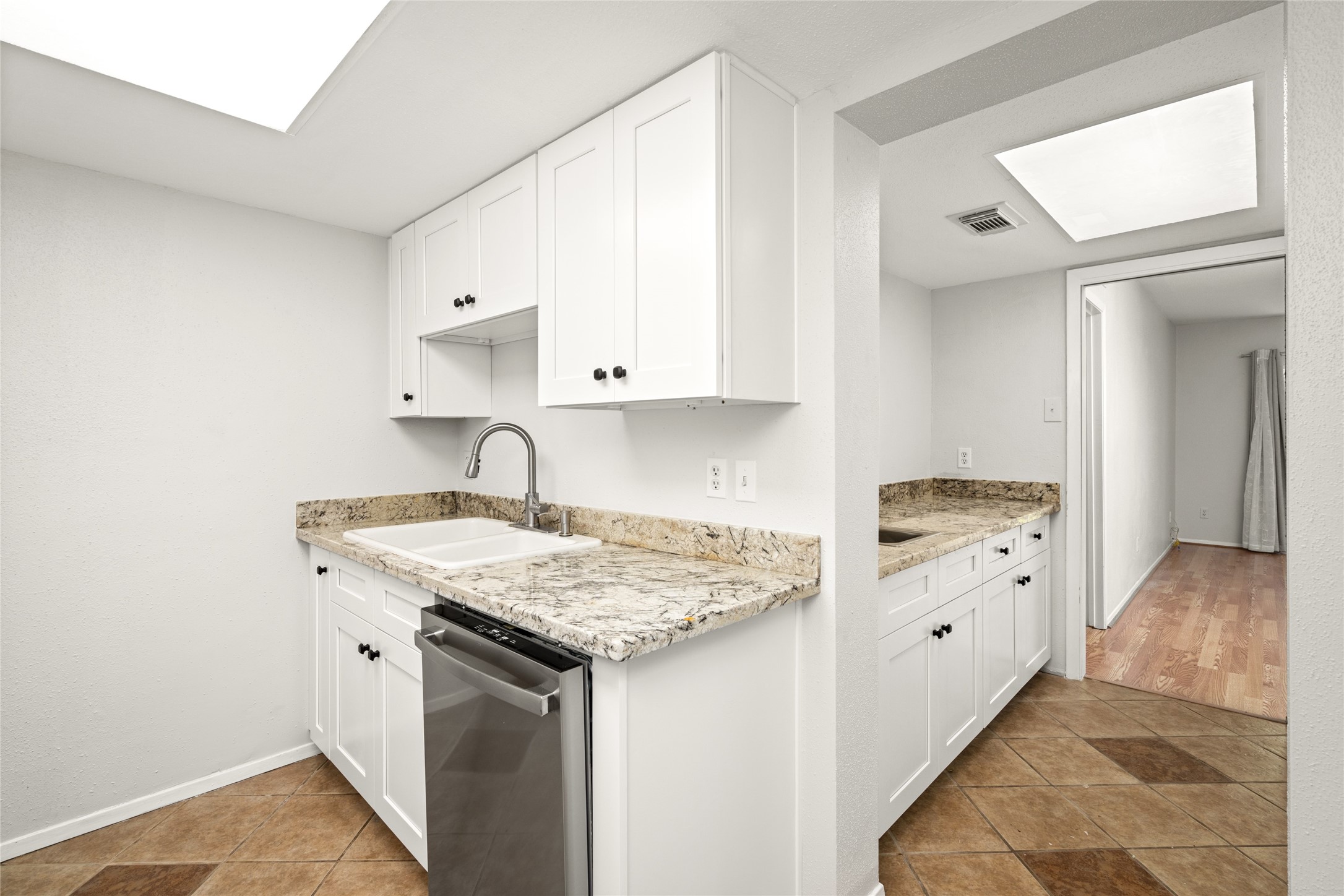 2238 South Piney Point Road, Unit 102 Houston, TX 77063 - Photo 7 of 20 a view of a kitchen with sink cabinets and wooden floor