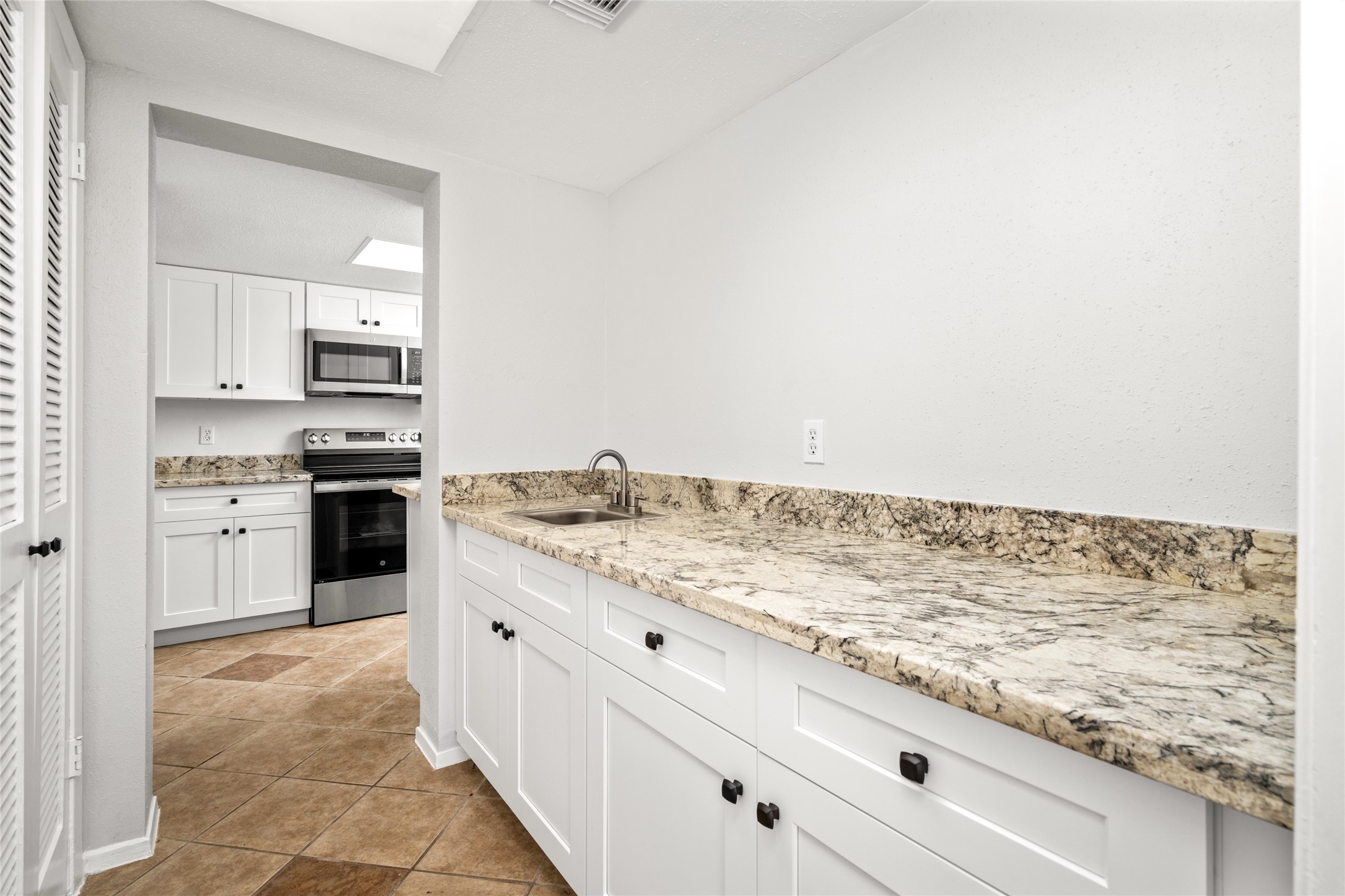 2238 South Piney Point Road, Unit 102 Houston, TX 77063 - Photo 8 of 20 a kitchen with granite countertop white cabinets and appliances