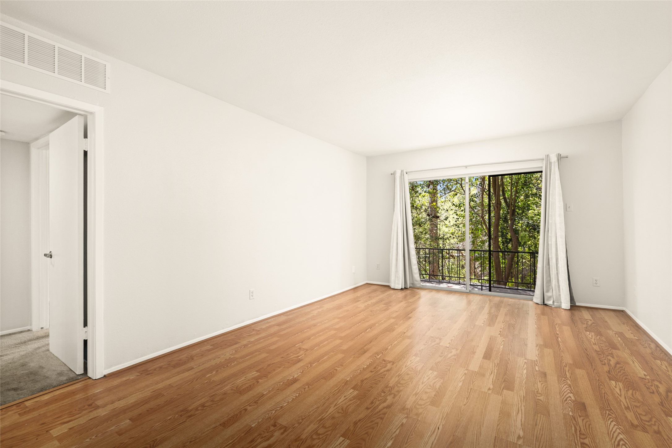 2238 South Piney Point Road, Unit 102 Houston, TX 77063 - Photo 10 of 20 a view of an empty room with wooden floor and a window