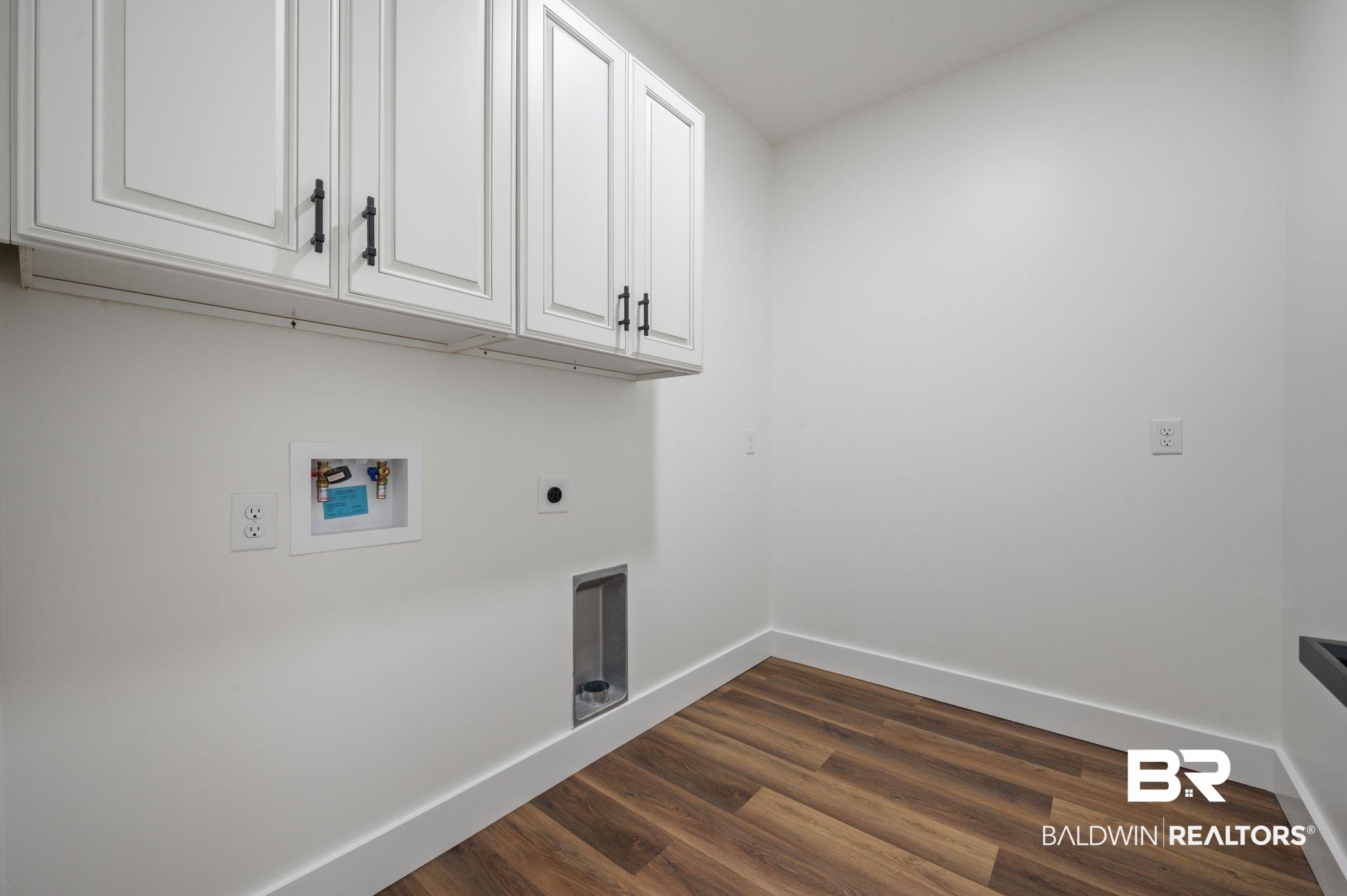 12100 Lott Road Chunchula, AL 36521 - Photo 13 of 21 Clothes washing area featuring hookup for a washing machine, hardwood / wood-style flooring, hookup for an electric dryer, and cabinets