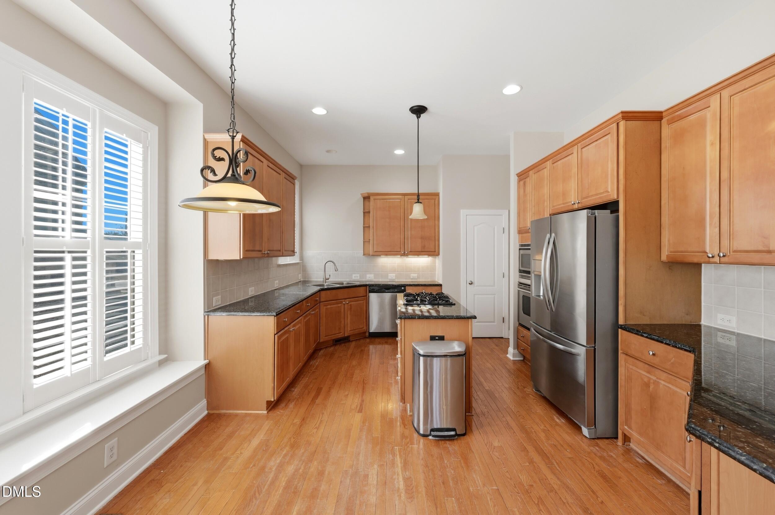 4803 Marena Place Durham, NC 27707 - Photo 8 of 42 a kitchen with a refrigerator a sink and a wooden floors