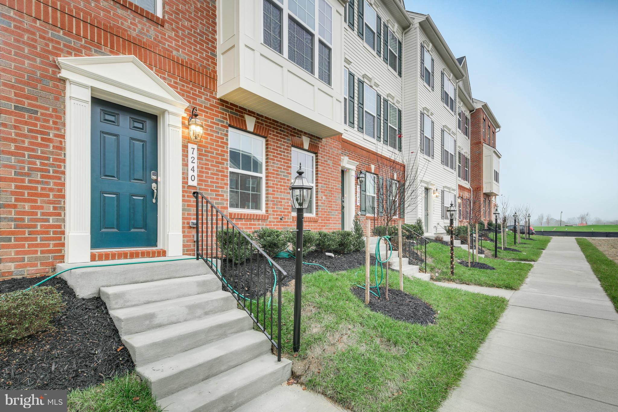 7240 Brinley Way Hanover, MD 21076 - Photo 2 of 22 a front view of a building with a yard