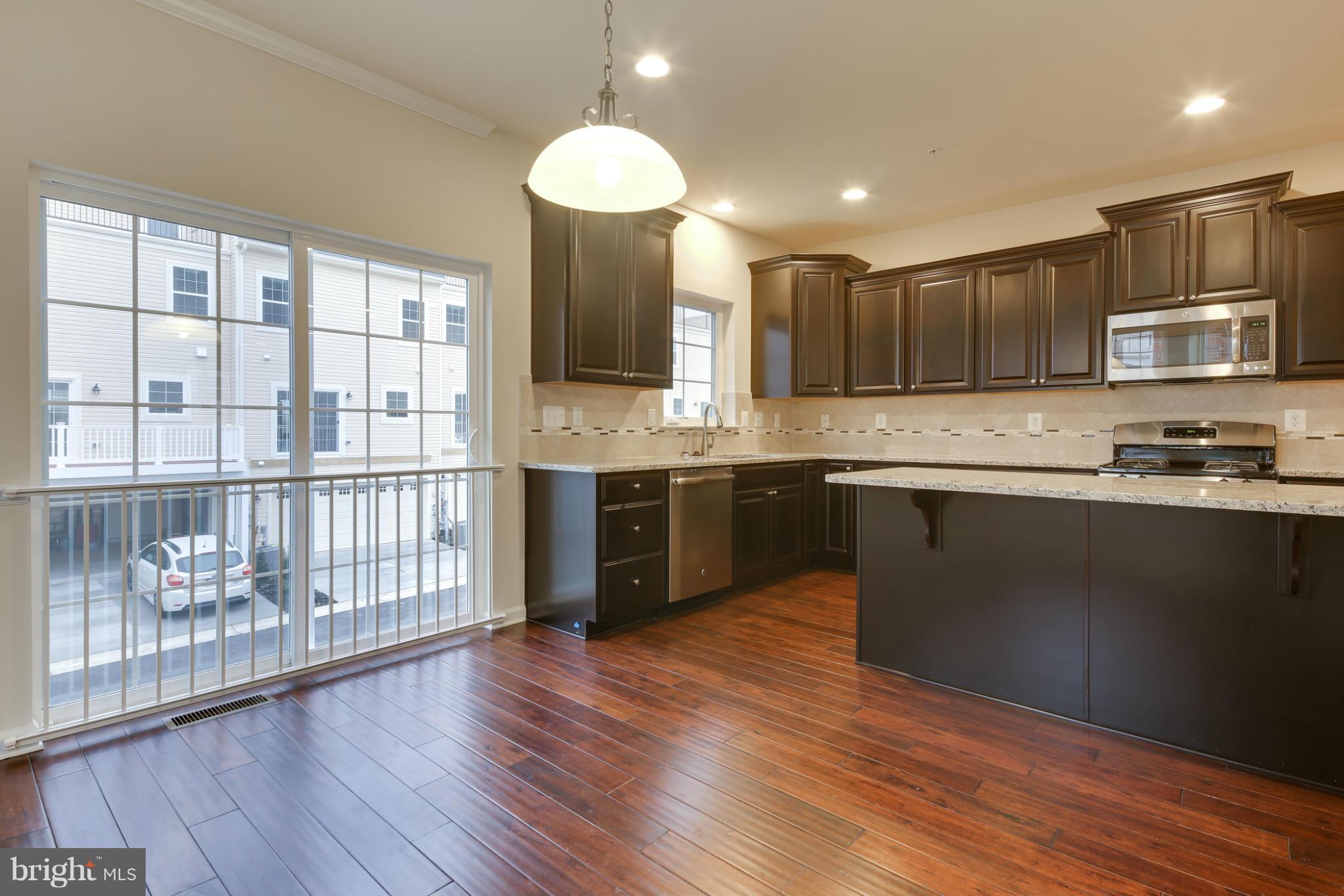 7240 Brinley Way Hanover, MD 21076 - Photo 11 of 22 a kitchen with stainless steel appliances granite countertop a stove a sink and a microwave