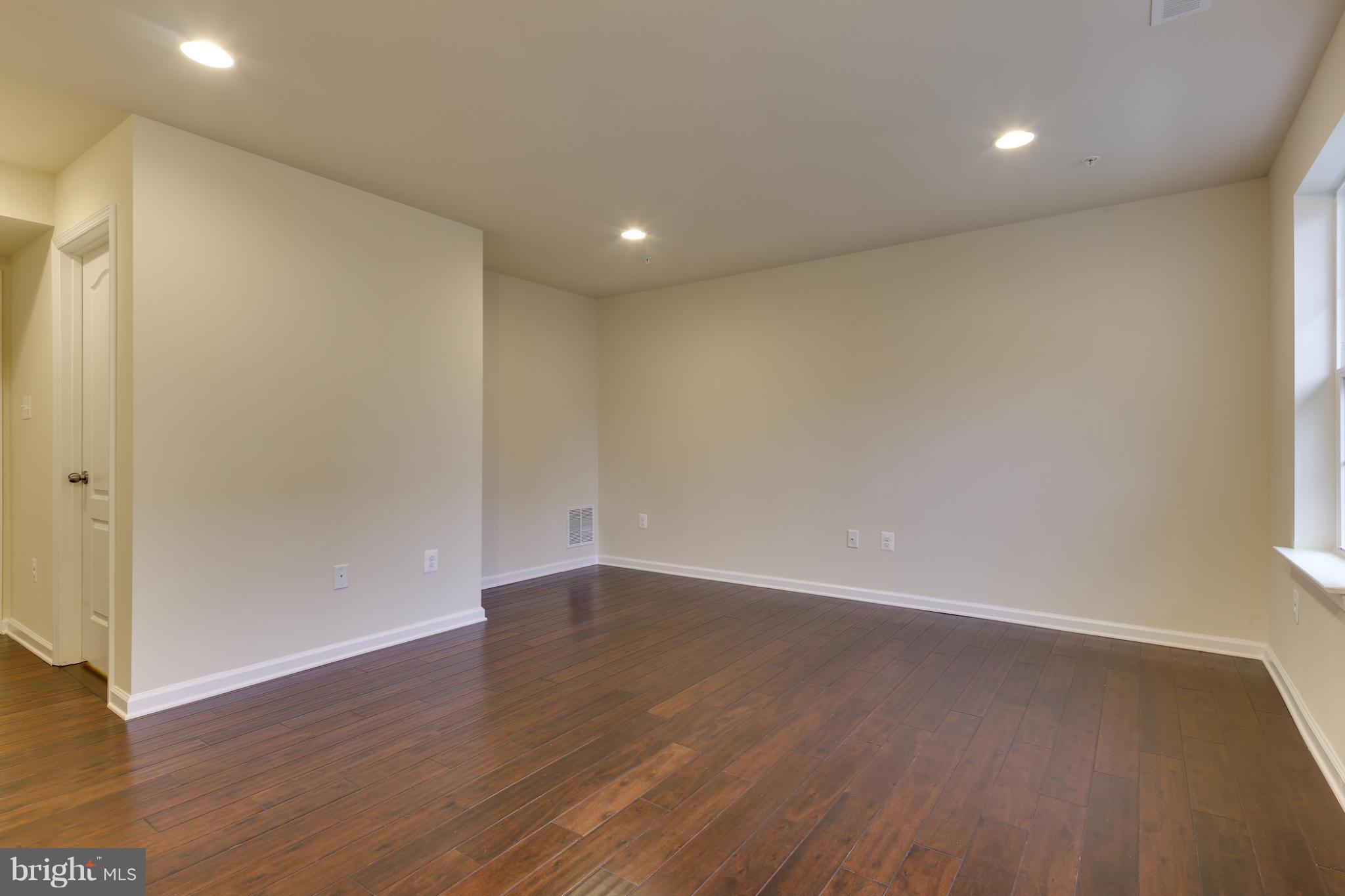 7240 Brinley Way Hanover, MD 21076 - Photo 3 of 22 an empty room with wooden floor and windows