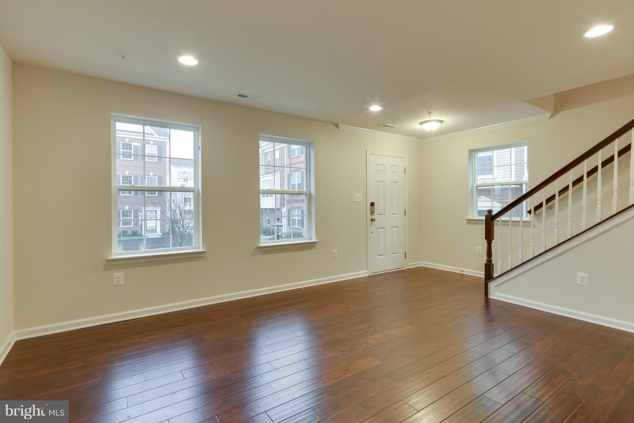 7240 Brinley Way Hanover, MD 21076 - Photo 5 of 22 a view of an empty room with wooden floor and a window