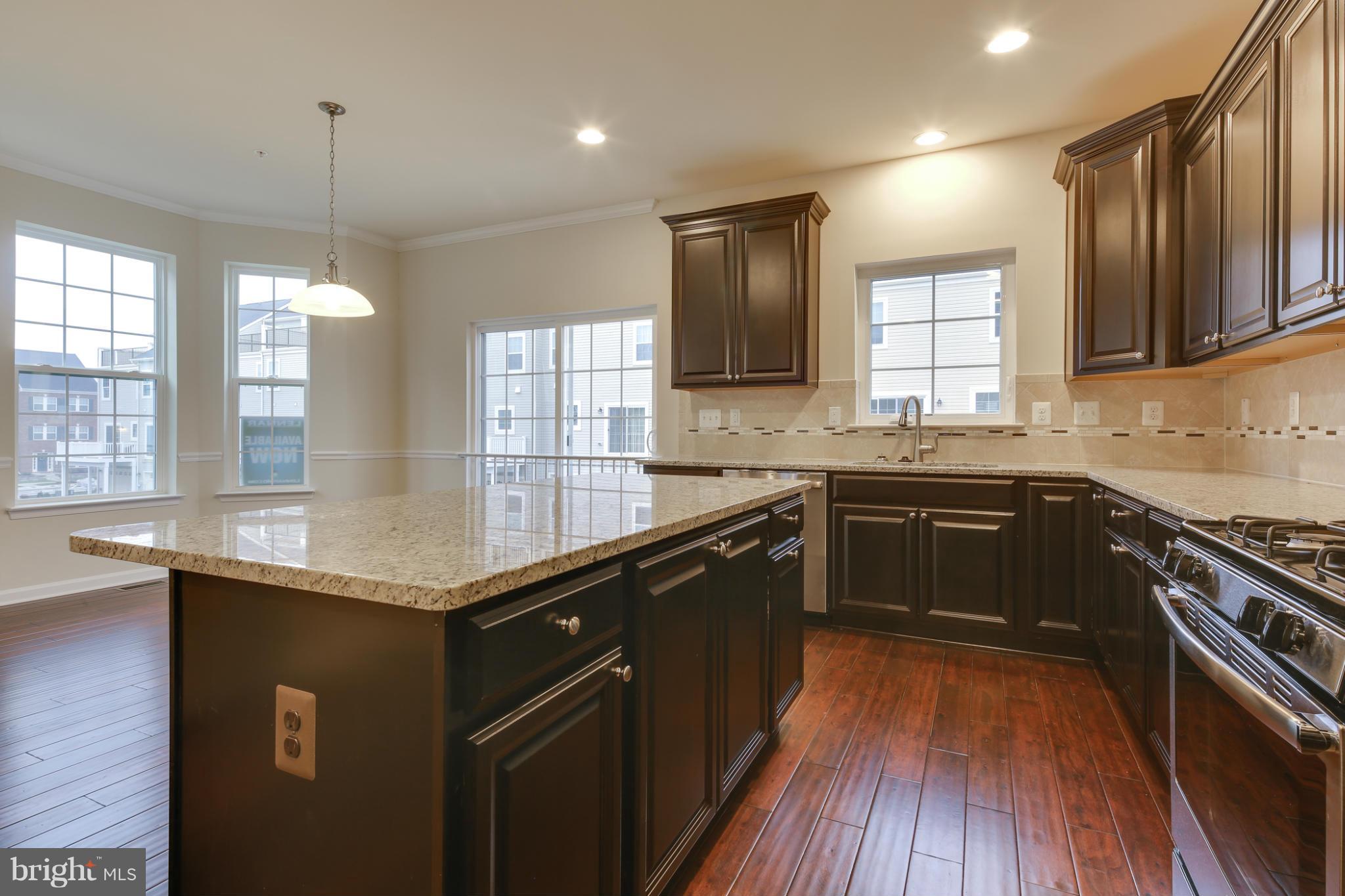 7240 Brinley Way Hanover, MD 21076 - Photo 7 of 22 a kitchen with stainless steel appliances granite countertop hardwood floor sink stove and granite counter top