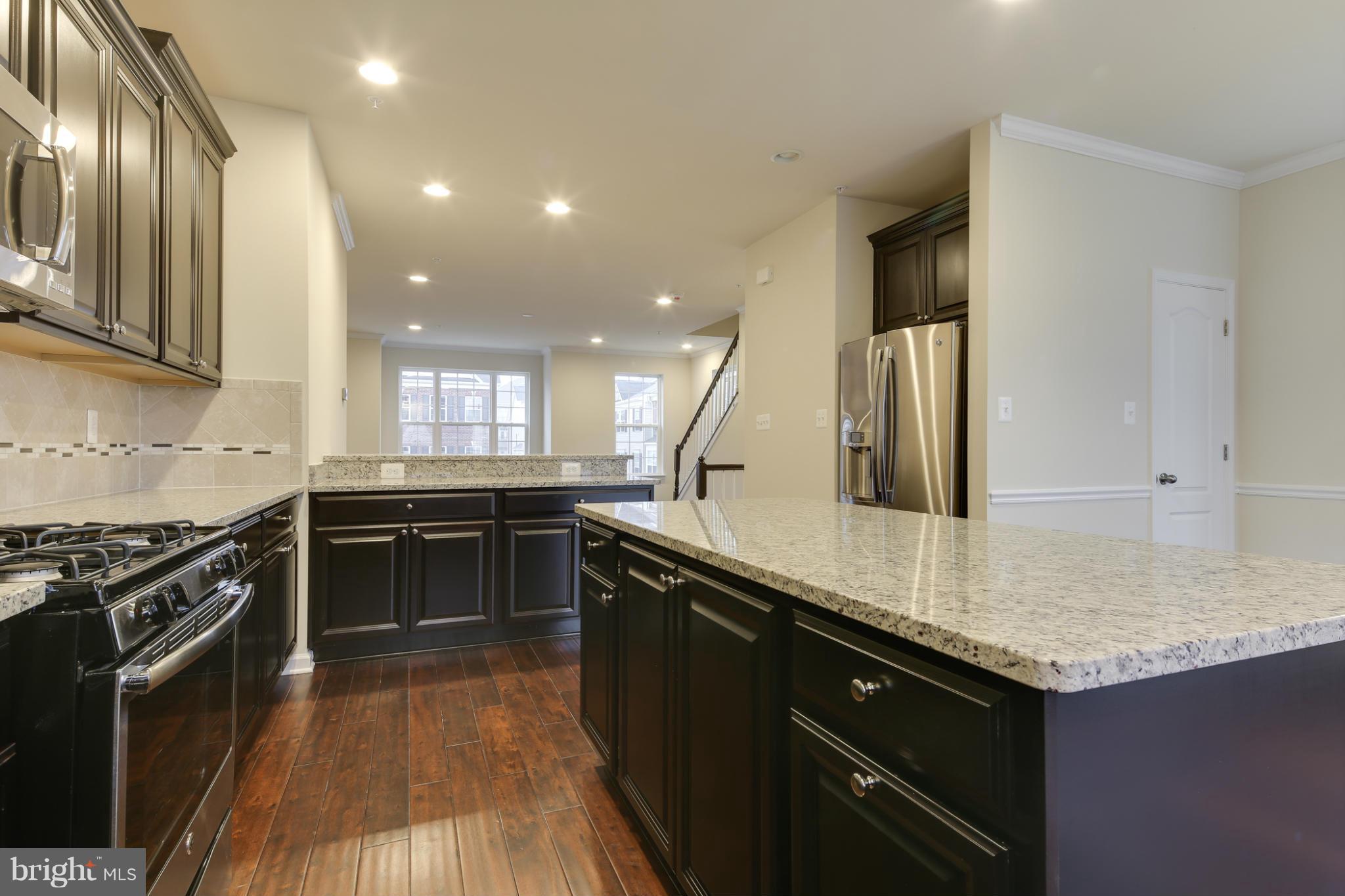 7240 Brinley Way Hanover, MD 21076 - Photo 8 of 22 a kitchen with a sink stove and cabinets