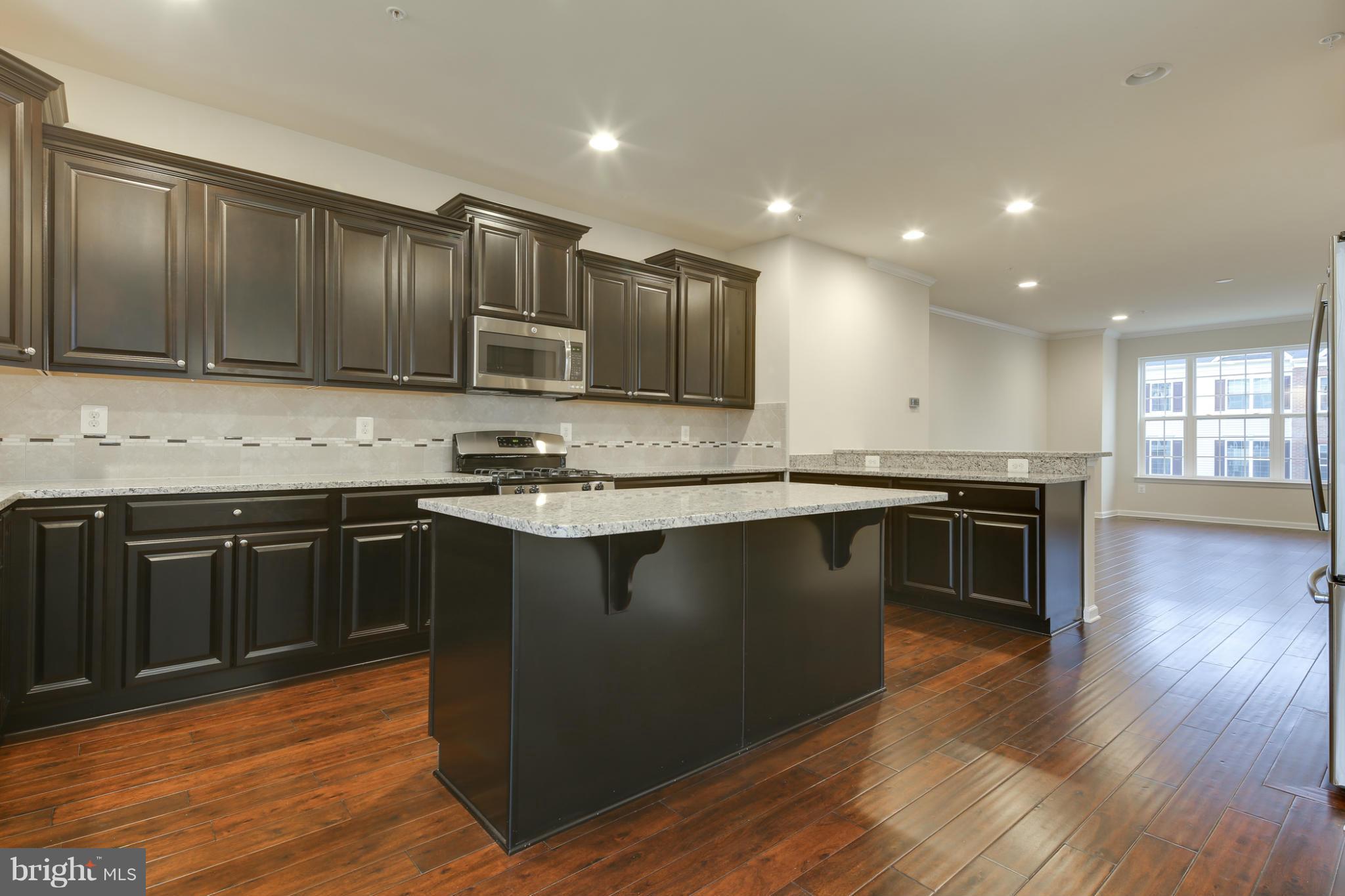 7240 Brinley Way Hanover, MD 21076 - Photo 9 of 22 a kitchen with stainless steel appliances granite countertop a stove a sink and a microwave