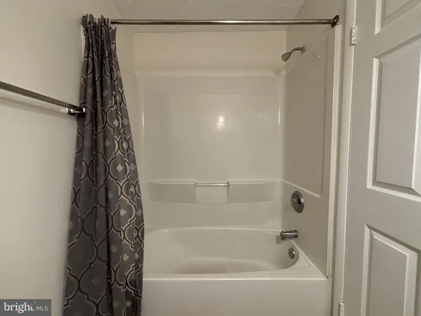 a bathroom with a shower curtain and a shower