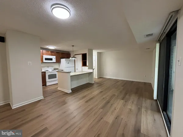 a view of kitchen with wooden floor electronic appliances and window