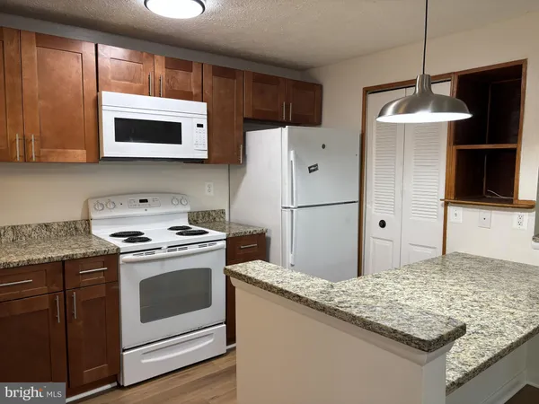 a kitchen with stainless steel appliances granite countertop a stove a refrigerator and a microwave