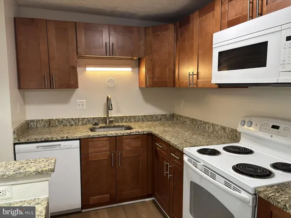 a kitchen with granite countertop a sink and a stove