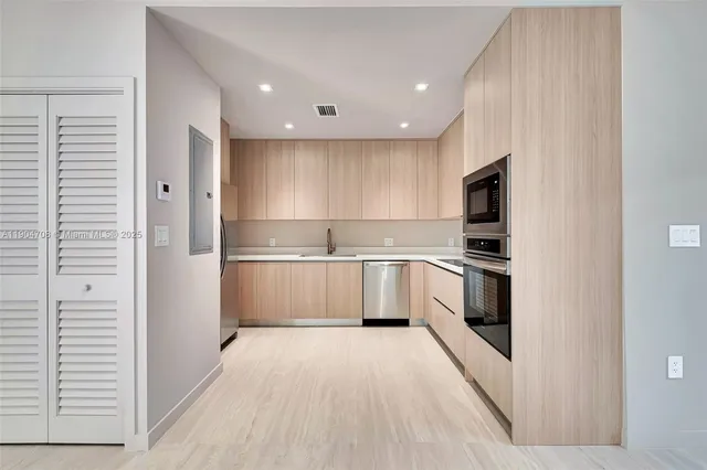 a kitchen with granite countertop a sink and stainless steel appliances