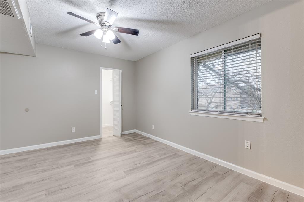 5833 Harvest Hill Road, Unit 2071 Dallas, TX 75230 - Photo 11 of 13 a view of an empty room with a window and wooden floor