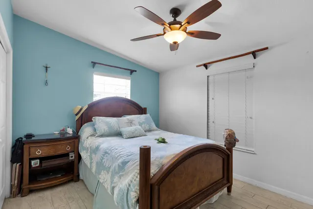 a bedroom with a bed and a ceiling fan