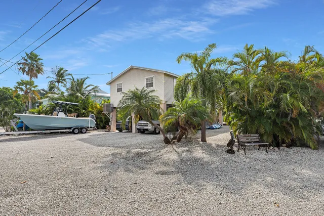 a view of a garden with a chair and potted plants