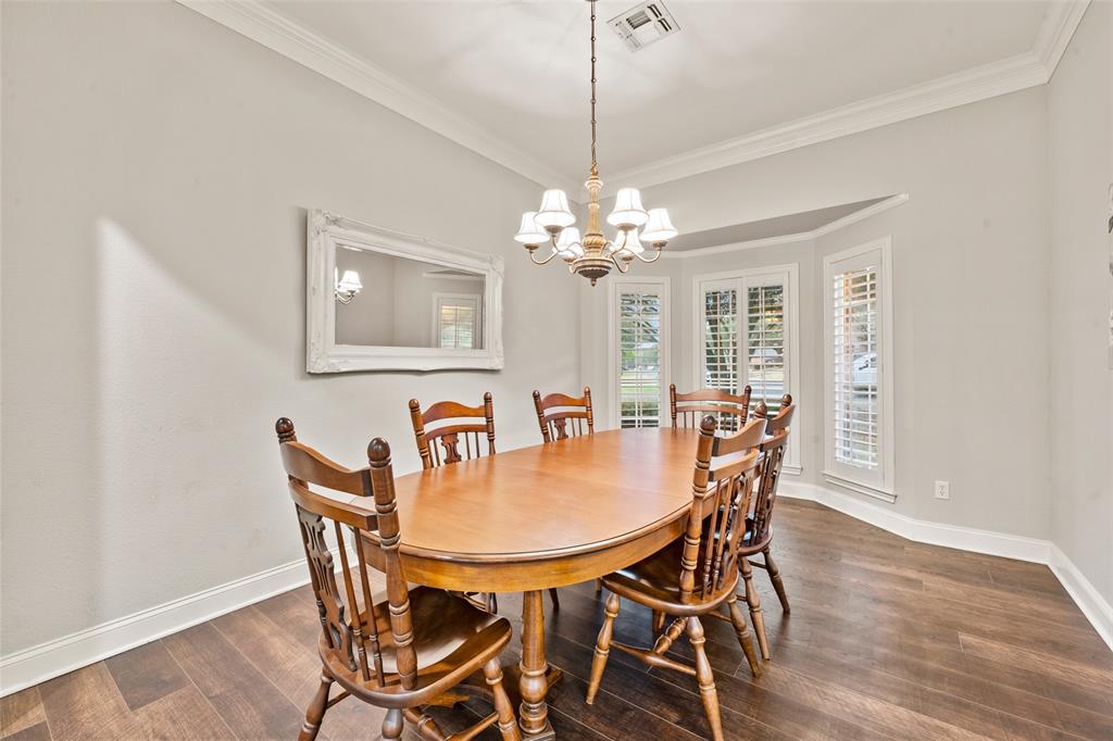 517 Chado Lane Robinson, TX 76706 - Photo 3 of 40 Dining space featuring dark wood-type flooring, suspended lighting, and crown molding